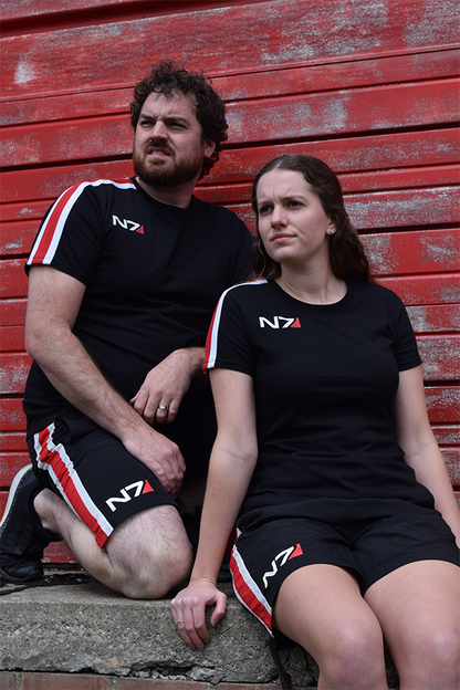 Image shows Mass Effect N7 Active Shorts worn by both a male and female model. Product features a unisex shorts that is perfect for workouts, sports, and other intense activities. Product doubles as casual lounge shorts as well.