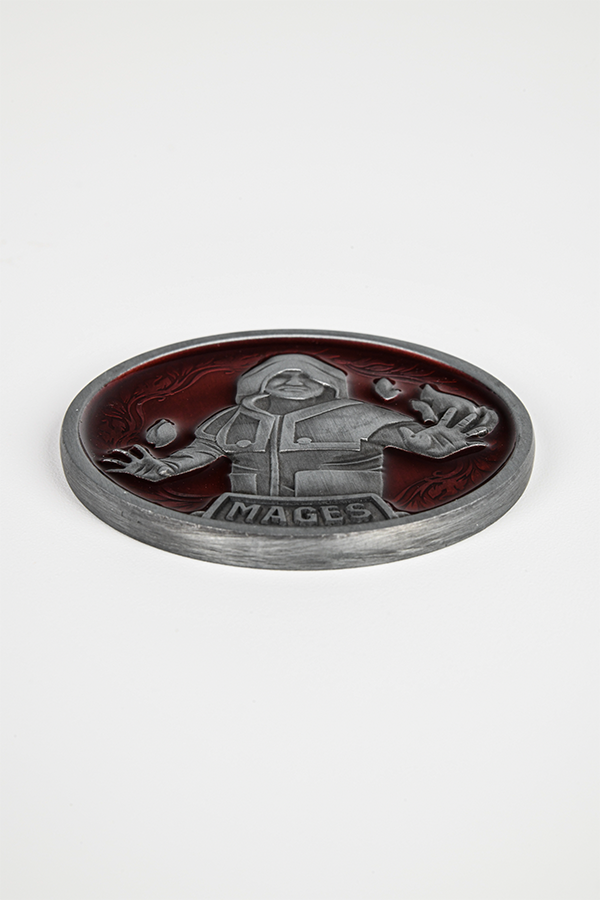 Image shows the Mage coin laid flat. Mage coin features an embossed design of a mage with a red background and vine pattern.