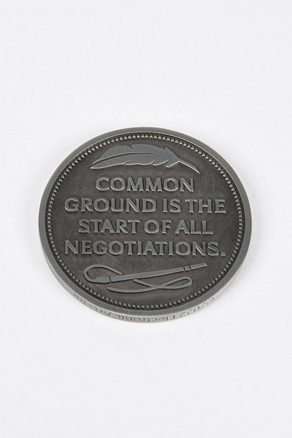 Image shows Dragon Agree Advisors Coin Set with one coin laid flat facing back with the text that reads "Common ground is the start of all negotiations"