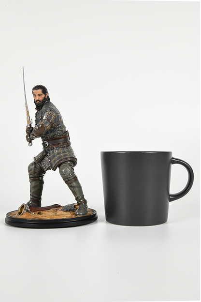 Image shows Dragon Age Blackwall Statue beside a black mug (for scale).