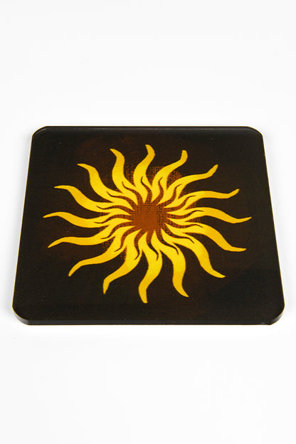 Image shows coaster with the Chantry heraldry symbol.  The symbol is a yellow sun over a dark brown background.