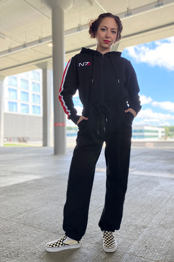 Image shows Mass Effect N7 Adult Onesie Reimagined worn by a female model facing front. Several N7 Operations took place during the Reaper War as part of the N7 Special Ops initiative.