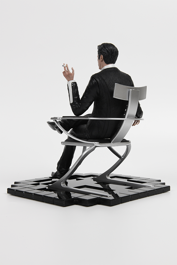 Image shows Illusive Man Statue facing back at an angle. Product features the Illusive Man holding out a cigar while sitting crossed legs. 
