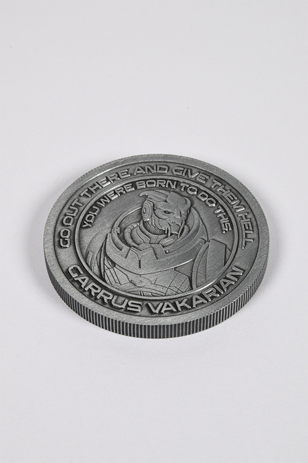 Image shows Mass Effect Coin Album's Garrus Coin laid flat facing front. Coin features Garrus' logo in the middle surrounded by one of his famous quotes. Garrus Vakarian is a turian, formerly part of C-Sec's Investigation Division. Like most turians, Garrus had his military training at fifteen, but later followed in his father's footsteps to become a C-Sec officer. He was responsible for the investigation of Saren Arterius, the Council's top Spectre, after the Alliance claimed Saren had gone rogue.