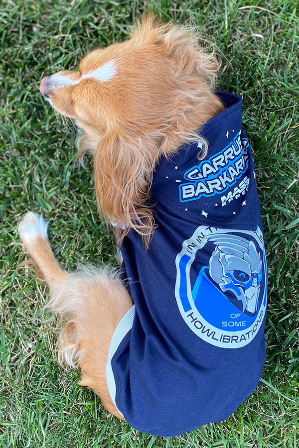 Image shows Mass Effect Garrus Barkarian Dog Tee worn by a dog while resting on a field of grass.