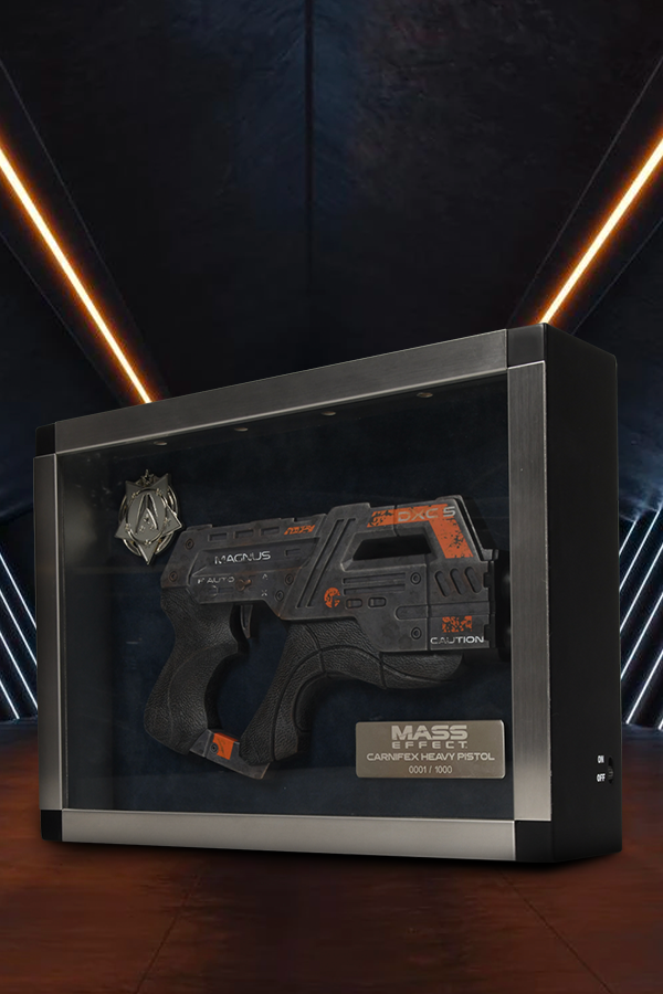 Image shows Mass Effect Carnifex Replica Shadowbox facing front at an angle. This replica is made using polyresin and displayed in an MDF wooden case finished with a stainless-steel frame. The shadow box includes a zinc alloy medal for your services at the systems alliance. Four spotlights at the top of the frame make it perfect for showcasing to all your guests and fellow systems alliance veterans.