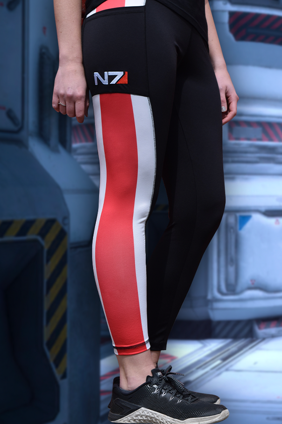 Image shows Mass Effect N7 Ankle Legging worn by model facing at an angle. Product is crafted with a mix of polyester and spandex, giving your legs a little bit of compression and a lot of stretch to move freely.