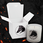 Image shows Dragon Age Fen Harel Scented Candle beside its box. With this scented candle, we have recreated the Dread Wolf’s spirit in its woody, musky wonder. Coconut soy wax is hand poured into a 6oz glass tumbler that is printed with Fen' Harel's image. Light it up in the evenings and go back to the time when the roamer of the beyond was among us.
