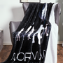 Image shows Mass Effect Team Throw Blanket thrown on top of a chair. Product is a 54 x 70 blanket made with 100% polyester printed flannel fleece with a solid white backside.  