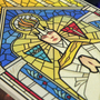 Image shows Dragon Age Andraste Stain Glass Holiday Ornament facing at an angle with the upper part zoomed in. Andraste is the prophet whose teachings later served as the foundation of both the Orlesian Chantry and Imperial Chantry. Andrastianism has since become the dominant religion in Thedas, believed by many to be the spiritual wife of the Maker.