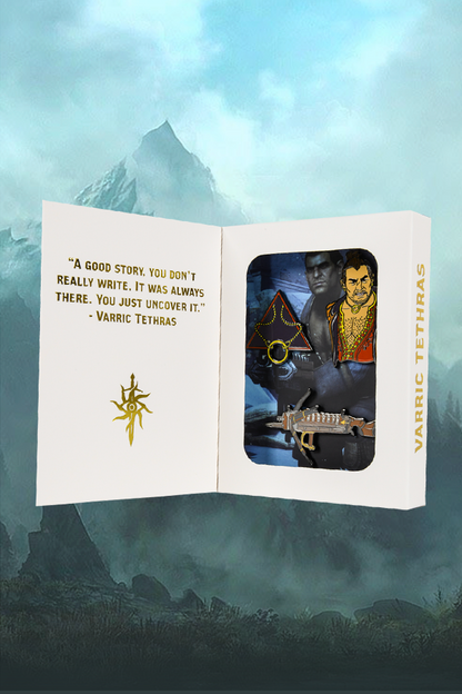 Image shows Dragon Age Varric Pin Set inside an open gift box. The right side shows the Varric pin set while the left of the box reads "A good story. You don't really write. It was always there. You just uncover it."