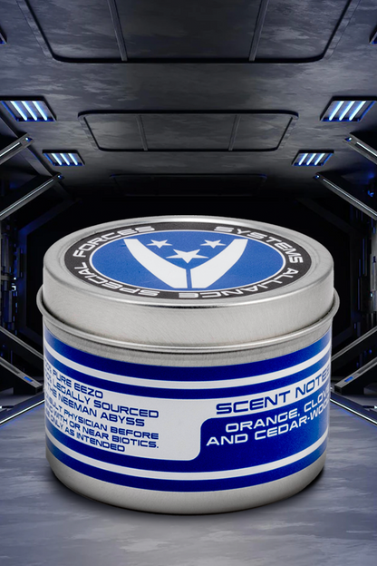 Image shows Mass Effect Element Zero Scented Candle facing back with its cap closed. Product comes in a 6oz tin with 3 custom game labels. Product is made with coconut soy wax and 100% cotton wick.