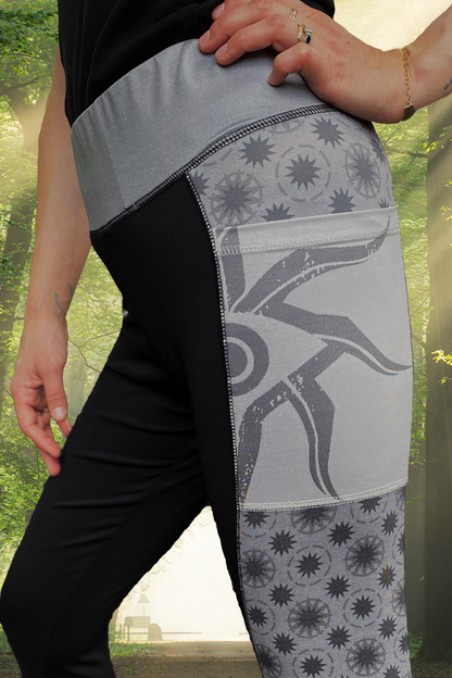  Image shows Dragon Age Inquisitor Leggings worn by model facing left. Product features side panel pockets and a reflective print logo on the wearer's right leg.