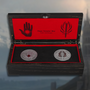 Image shows Dragon Age Mage-Templar War Coin Set's box opened with both coins sitting in a velvet-lined display. The box is a black wooden box with red lining and colored artwork of the Mage-Templar war.