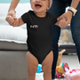 Image shows female baby model being walked while wearing the N7 I Have To Go Baby Onesie. Product features flatlock stitched seams and an innovative three-snap closure.