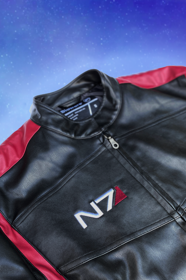 Image shows Mass Effect N7 Jacket Reimagined laid flat with the upper part of the jacket zoomed in. Jacket features a right chest logo embroidery and front zip closure.