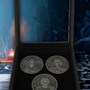 Image shows Dragon Age Three Advisors Coin Set with all coins inside the box. The box is a wooden display box with glass top. its measurements are 5.16