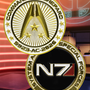 Image shows Mass Effect N7 Premium Box's System Alliance coin with the front and back of the coin facing front. The coin is made of zinc alloy with imitation gold plating and soft enamel. The Systems Alliance is the representative body of Earth and all human colonies in Citadel space. Backed by Earth's most powerful nations, the Alliance has become humanity's military, exploratory, and economic spearhead.