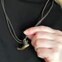  Image shows Dragon Age Solas Jawbone Necklace worn by model with the necklace zoomed in. Product is 1 3/8