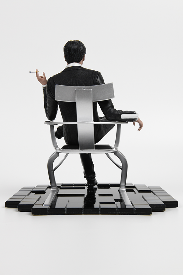 Image shows Illusive Man Statue facing back. Product highlights an individually weled chair and an acrylic base. 