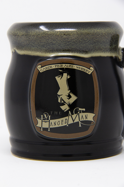 Image shows Dragon Age The Hanged Man Tavern Mug with its emblem zoomed in. The Hanged Man Tavern is located lowtown, in the lower parts of Kirkwall north of the docks.