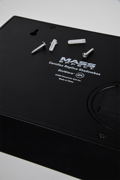 Image shows Mass Effect Carnifex Replica Shadowbox laid flat facing back. The back of the shadowbox shows the Mass Effect, Bioware, and EA logos.