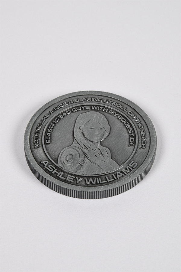 Image shows Mass Effect Coin Album's Ashley Williams coin laid flat facing front. Coin features Ashley Williams' logo in the middle surrounded by one of her famous quotes. Ashley Madeline Williams is a human soldier who served in the Systems Alliance as a Gunnery Chief in the 2nd Frontier Division on Eden Prime, and was later assigned to Commander Shepard's squad after the geth attack on Eden Prime. She is a potential romance partner for a male Shepard.