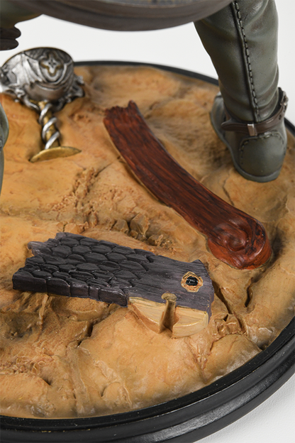 Image shows Dragon Age Blackwall Statue's circular base zoomed in. Circular base features a realistic desert surface that is detailed with a goblet and other abandoned wares.