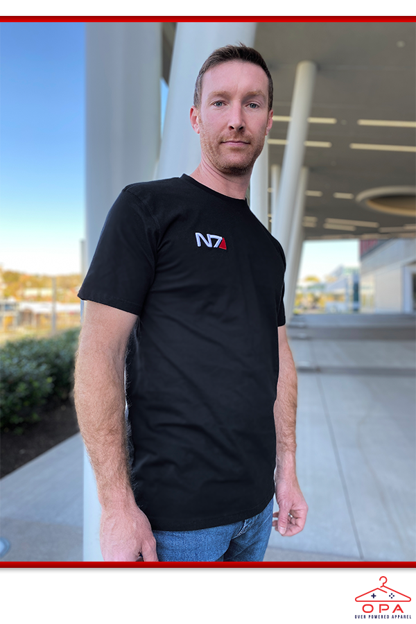 Image shows Mass Effect N7 3D Embroidered OPA T-Shirt worn by male model facing front, During the Reaper war, Allied forces began recruiting anyone, soldier or mercenary, to serve on the front lines of the conflict. The most experienced operatives formed squads to secure objectives, evacuate civilians, and battle Cerberus or the Reapers deep in enemy territory. Initially led by N7 commandos, these squads were nicknamed the N7 Special Ops.