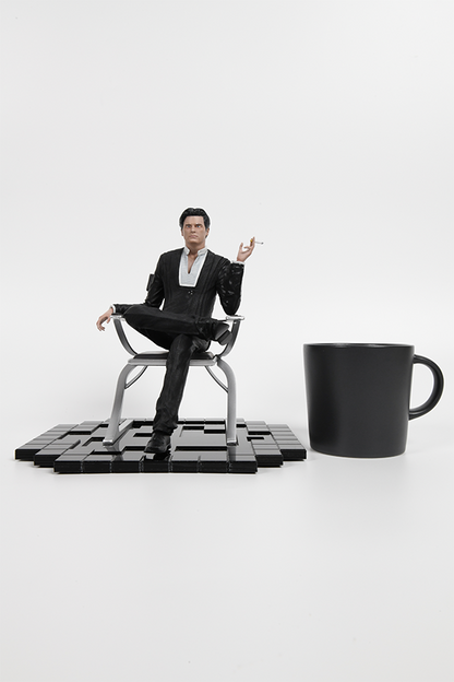 Image shows Illusive Man Statue sitting next to a black coffee mug. Product is 22cm in length, 20cm in width and 21.8cm in height.