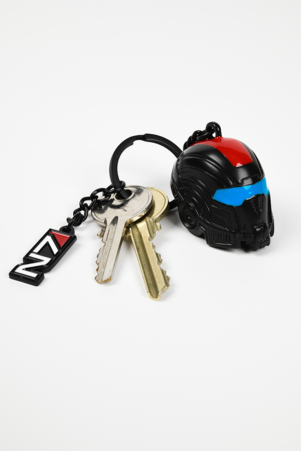 Image shows Mass Effect N7 Helmet Keychain facing at an angle with keys attached and the N7 logo charm laid on the side. Add it to your car keys or keybunch to give them a legendary makeover.