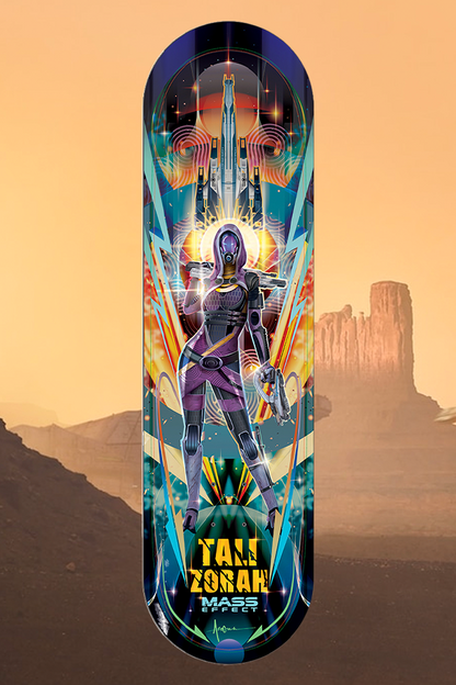 Image shows Mass Effect Tali Zorah Skate Deck with the deck side facing front. . Designed by our in-house artist, the colorful deck showcases Tali’s gorgeous purple environmental suit with its intricate swirls and patterns. Ans behind her, amidst the vibrant patterns, is the SSV Normandy. Stars and mesmerizing nebulas cover the background of this deck.
