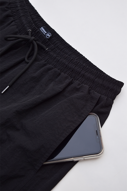  Image shows Mass Effect N7 Active Shorts laid flat with a phone on its pockets. Product has breathable material and quick dry fabric and features side seam pockets. 