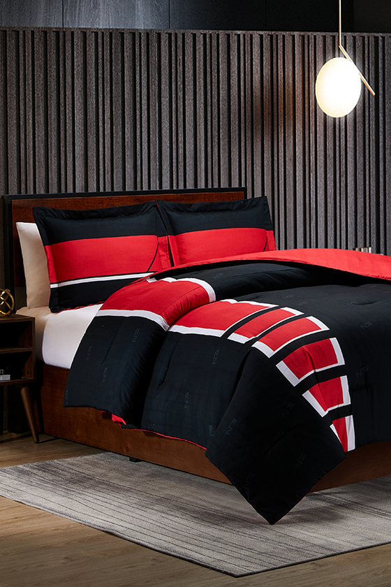 Image shows Mass Effect N7 Bed in a Bag arranged in a bed. Set includes comforter and pillows. The product boasts the red, white, and black colors of the N7. This N7 Bed drapes your wearied body in warmth and comfort.